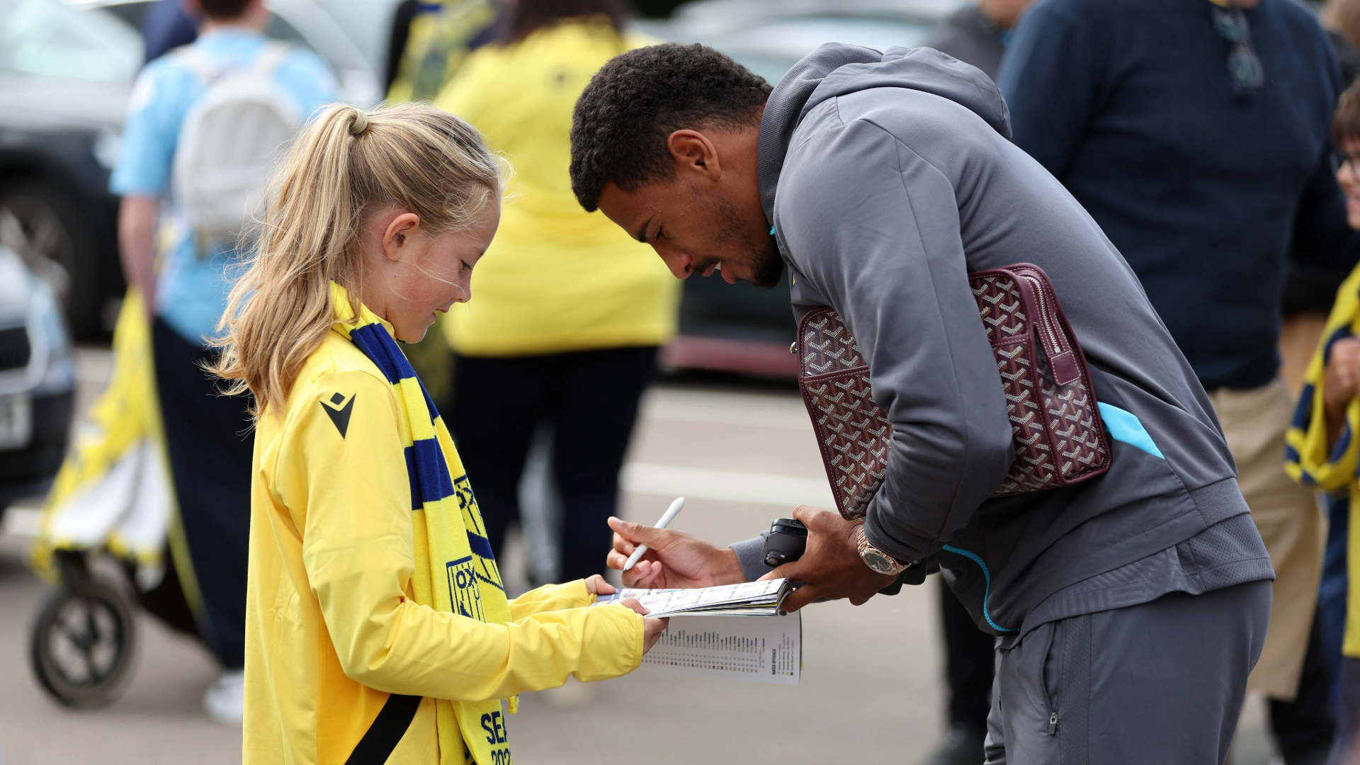 Marcus McGuane signing an autograph for a young fan
